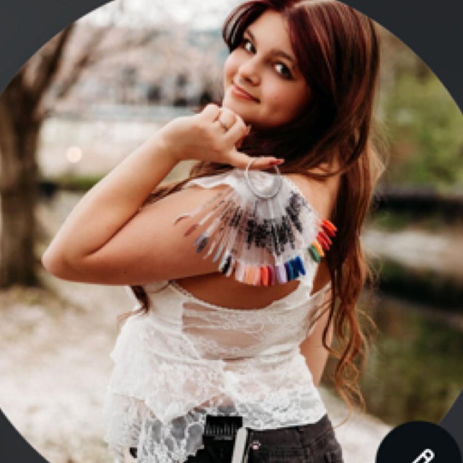 Ava, nail artist, holding a nail color swatch wheel